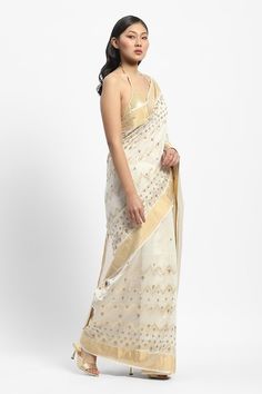 Ivory chanderi saree embroidered with golden threads and pearls. Comes with running blouse piece. - Aza Fashions White Chanderi Pre-draped Saree For Celebration, Festive Beige Pre-draped Saree, White Chanderi Pre-draped Saree With Zari Work, Transitional Gold Saree With Dori Work, Off White Designer Pre-draped Saree For Festive Occasions, Festive Cream Pre-draped Saree With Cutdana, White Pre-draped Saree With Zari Work, Gold Cotton Silk Pre-draped Saree For Reception, Festive Designer Cream Pre-draped Saree