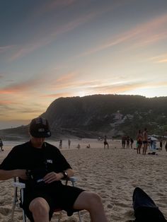 a man sitting in a chair on the beach