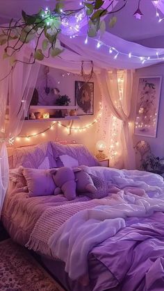 a bed room with a neatly made bed covered in purple sheets and pillows next to hanging lights