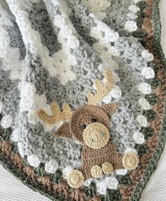 a crocheted blanket with a stuffed animal on it's back and bottom