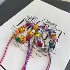 several colorful bracelets with smiley faces on them sitting on top of a magazine page