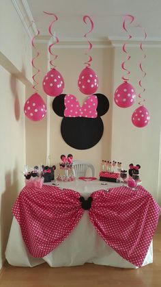 a minnie mouse birthday party with pink and white decorations