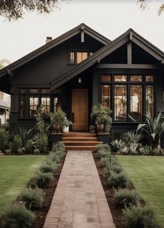 a house that has some plants in the front yard and steps leading up to it