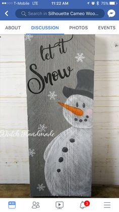 a wooden sign with a snowman painted on it's side and the words let it snow