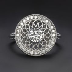 an antique style diamond ring with filigrees on the sides and round brilliantly set in white gold