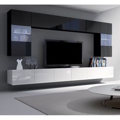 a modern living room with black and white entertainment center, bookshelf and large screen television