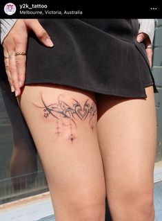 a woman's thigh with tattoos on it and her leg showing the side view