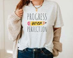 ♡ Celebrate the journey of learning with our "Progress Over Perfection" Teacher Shirt, designed especially for educators who value growth and development over flawless results.  ♡ This shirt is perfect for special education, kindergarten, and elementary teachers who inspire daily. It makes a thoughtful gift for any educator or a great choice for teacher team shirts. ♡ Crafted from soft, breathable fabric, our teacher tee is comfortable for all-day wear, whether in the classroom or at school even Teacher Team Shirts, Teacher's Quotes, Progress Over Perfection, Teacher Team, Teacher Outfit, Education Kindergarten, Teacher Style, Teacher Tees, Special Education Teacher