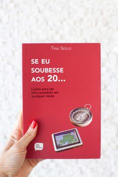 a person holding up a red book in front of a white wall with the title se eu soubesse aos 20