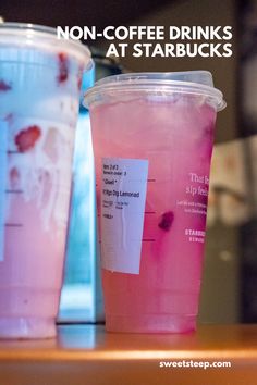 two plastic cups filled with liquid sitting on top of a table