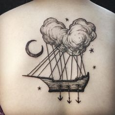 the back of a woman's shoulder with an image of a boat and clouds on it