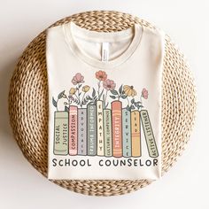 a t - shirt that says social worker with books and flowers on it in front of a wicker basket