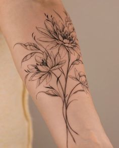 a woman's arm with flowers and leaves tattoo on the left side of her arm