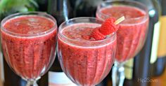 three wine glasses filled with raspberry champagne and garnished with fresh raspberries