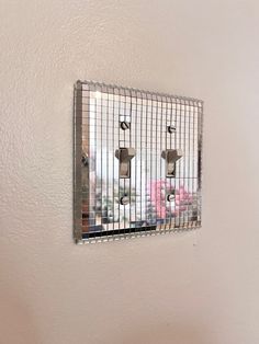 there is a mirror on the wall that has some metal bars attached to it,