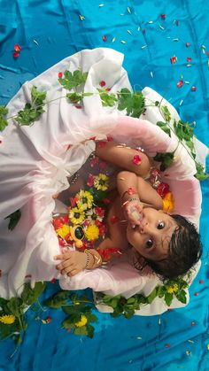 an overhead view of a baby in a bathtub with flowers