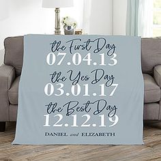 a personalized blanket with the names and date printed on it, sitting in front of a couch