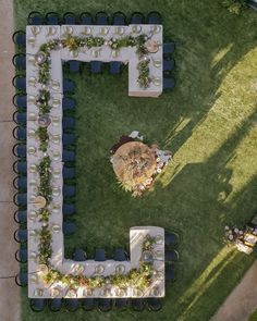 an aerial view of a table and chairs set up in the middle of a lawn