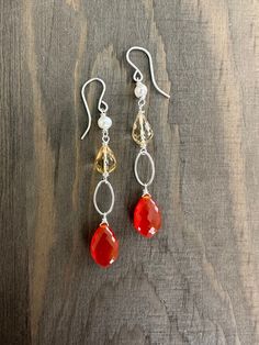 A beautiful pop of orange with shades of yellow and pearl complete these pretty earrings.  A bright orange carnelian dewdrop hangs below an open oval, a citrine teardrop, and freshwater pearl.  All metal components are sterling silver.  The earrings measure 2.25 inches from the top of the ear wire to the bottom of the carnelian. Orange Teardrop Gemstone Earrings, Orange Carnelian Dangle Earrings, Orange Carnelian Gemstone Earrings, Orange Gemstone Dangle Earrings, Orange Carnelian, Tear Drop Earrings, Yellow Citrine, Pretty Earrings, Shades Of Yellow