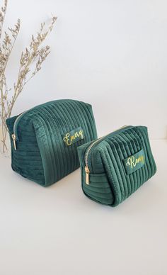 two green velvet cosmetic bags with gold zippers on the front and side, one is empty