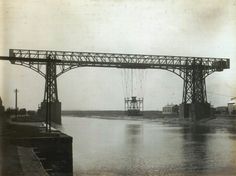 an old black and white photo of a bridge over water