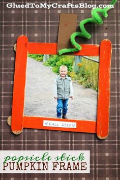 an orange frame with a child's picture in the middle and a green snake on top