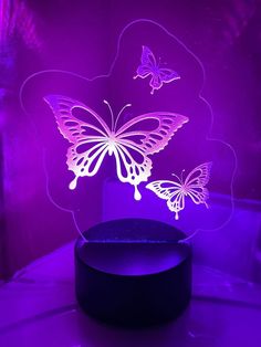 a purple light with two butterflies on it and a black box in the foreground