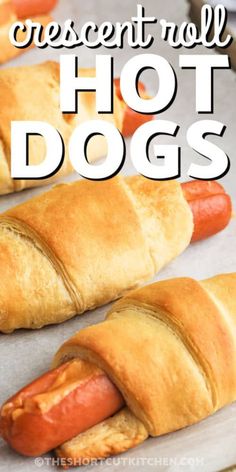 hot dogs wrapped in crescent rolls on a baking sheet with text overlay that reads crescent roll hot dogs