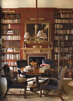 a dining room table surrounded by chairs and bookshelves