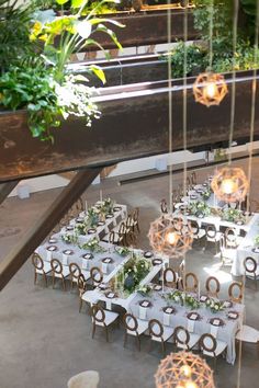 an outdoor dining area with tables and chairs set up for a formal function, surrounded by greenery