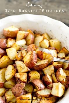 a white bowl filled with cooked potatoes on top of a wooden table next to a spoon