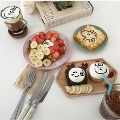 a table topped with desserts and drinks on top of plates next to utensils