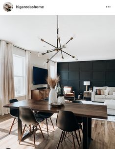 a dining room table with four chairs and a vase on top of it in front of a couch