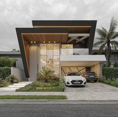 two cars parked in front of a modern house