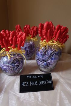 four vases with red and purple flowers in them on a white table cloth covered table