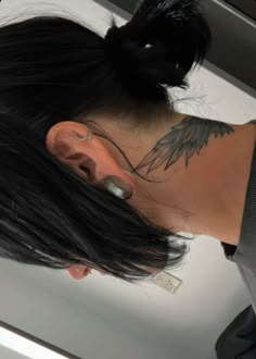 a woman with tattoos on her neck and ear