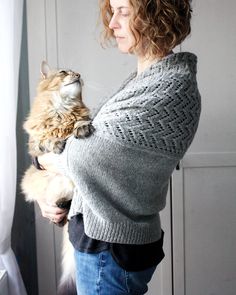 a woman holding a cat in her arms