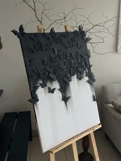 an easel with some black butterflies on it