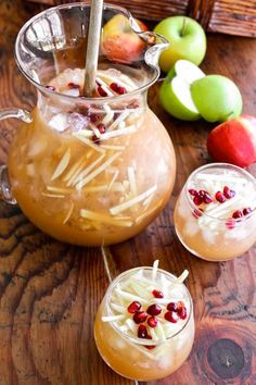 two glasses filled with apple cider punch and garnished with pomegranates