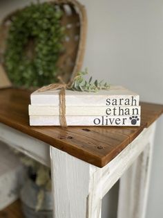 two books tied with twine sitting on top of a wooden table next to a potted plant