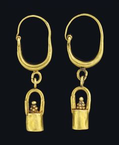 two pairs of gold earrings, one with a lock and the other with a skull on it