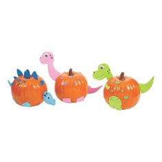 three plastic dinosaurs and pumpkins on a white background