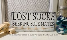 a sign that says lost socks seeking sole mates next to a jar with blue and white candies in it