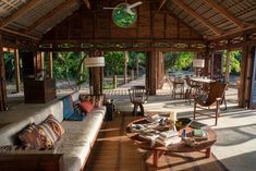 a living room filled with furniture and lots of wood beams on top of the ceiling