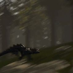 a blurry image of a dinosaur running through the woods in front of some trees