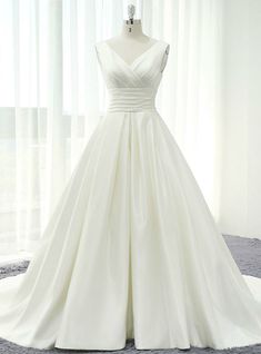 a white wedding dress on display in front of a window