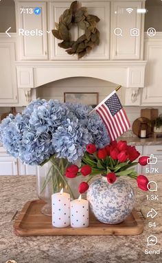 blue hydrangeas and red flowers in a vase on a kitchen countertop with an american flag