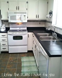 a kitchen with white cabinets and black counter tops