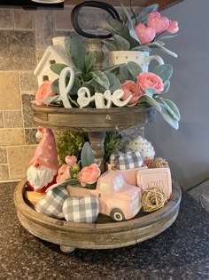 a three tiered tray filled with flowers and figurines