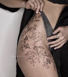 a woman's thigh with flowers on it and her hand holding the side of her leg